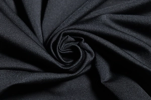 Macro shot of high-density black pleated fabric with fine vertical texture and silk luster