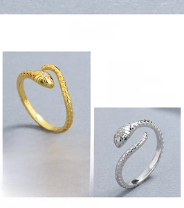 Detail of adjustable S925 sterling silver snake ring with green stone eyes and scale texture