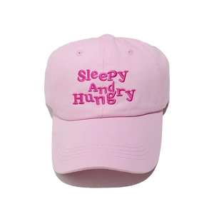 Détail d'une casquette rose en coton avec broderie Sleepy And Hungry et coutures précises