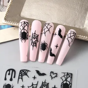 Macro detail of Halloween nail stickers with black spider webs and bats on pink nails