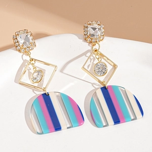 Macro shot of stylish resin geometric drop earrings with crystals and colorful stripes