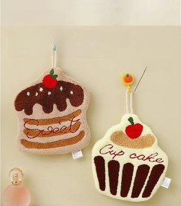 Detail of hanging coral velvet hand towels with cupcake and sweet embroidery designs