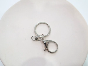Dettaglio della chiusura a moschettone in argento e anello per chiavi su rosa