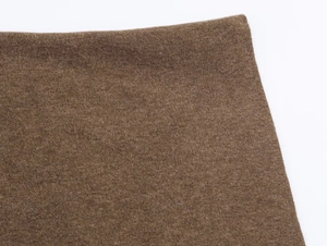 Macro view of dark brown knitted poncho showing fine cashmere texture and premium fabric weave