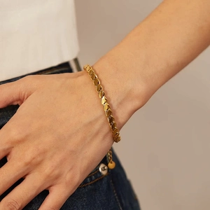 Minimalist gold hollow heart bracelet with wheat chain design worn on a woman's wrist