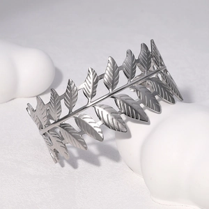 Minimalist silver leaf open bangle bracelet with detailed vein texture on white cloud prop