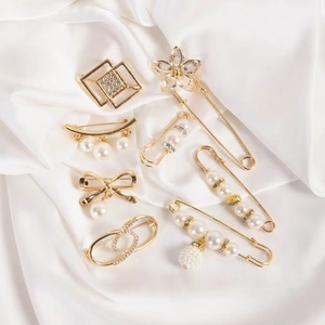 Set of 8 gold pearl waist pins with bows and flowers on white silk background