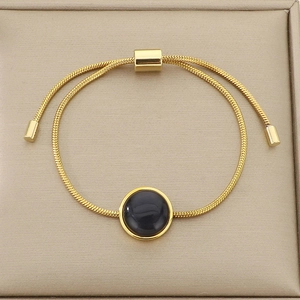 Détail du bracelet chaîne serpent dorée avec pierre noire et fermoir ajustable