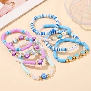 Macro view of Bohemian beaded bracelet set featuring polymer clay and gold charms