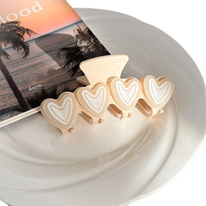 Creamy heart hair claw clip with four acetate 3D hearts in a decorative dish