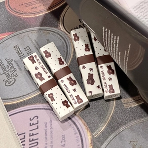 Cute retro bear pattern matte lipstick set in white and brown cases on vintage paper