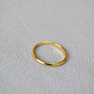 Macro shot of minimalist gold plated brass wavy ring showing smooth texture and curve