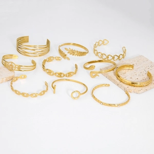 Detailed set of ten gold hollow heart and snake patterned stainless steel bracelets