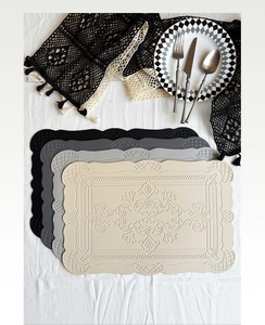 Close-up of rectangular PU leather placemats with embossed patterns and wavy edges