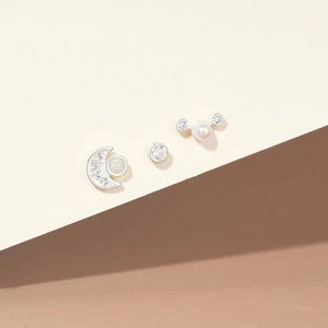 Detail of 925 silver earring set with opal moon, round diamond, and pearl studs