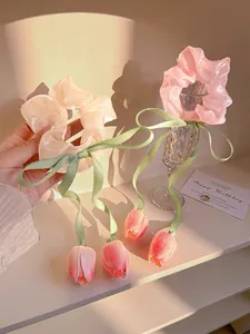Detail of pink organza hair scrunchie with long green ribbon and tulip pendant