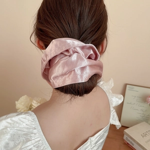 Pink satin scrunchie detail showing soft silk texture and elegant drape on hair