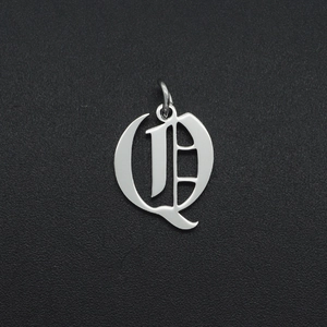 Detailed close-up of a silver Gothic style letter Q pendant in polished stainless steel