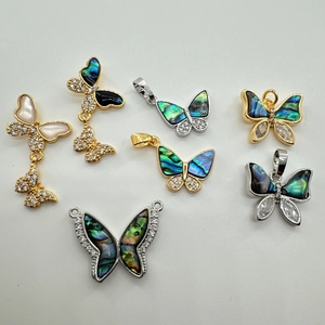 Vue détaillée de pendentifs papillon en or 18 carats et argent avec nacre nacrée