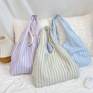 Detailed macro shot of three striped canvas tote bags in colorful pastel summer tones