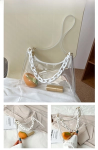Close-up of transparent PVC shoulder bag with decorative white plastic chunky chain strap