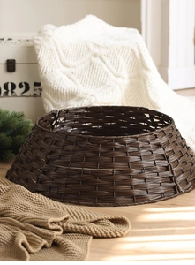 Close-up of hand-woven dark brown rattan Christmas tree skirt in a cozy home setting