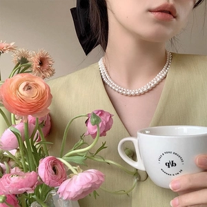 French vintage double-layered pearl necklace worn with floral and cafe background