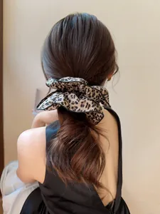 Dettaglio di un elastico per capelli leopardato oversize con bordo nero su coda