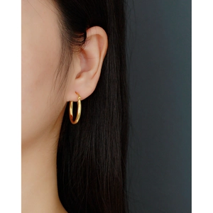 Elegant 925 sterling silver minimalist golden hoop earrings worn by a model