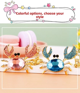 Macro view of crystal encrusted crab keychains in pink and blue finishes with lobster clasps