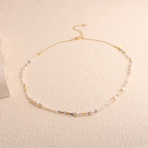 Detailed macro view of baroque freshwater pearl necklace with golden lobster clasp and beads