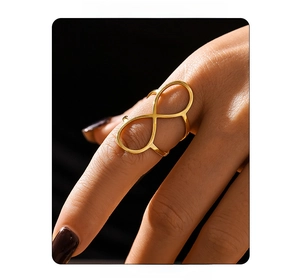 Macro shot of gold infinity symbol ring with polished finish on model's finger