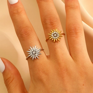 Detail of sunflower rings with white crystals in gold and silver finish on finger