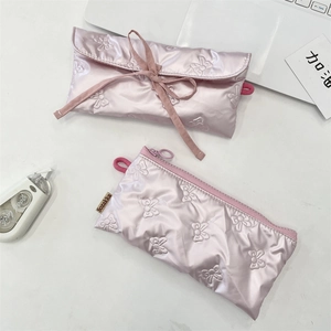 Détail de trousses à crayons roses matelassées avec nœud et fermeture éclair