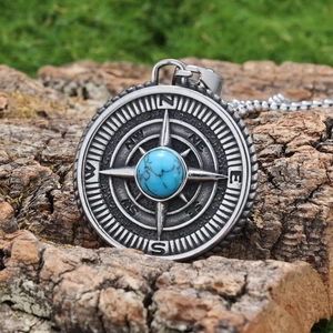 Macro detail of Viking compass pendant with turquoise inlay on natural tree bark texture