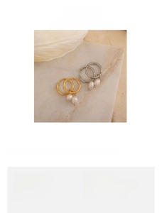 Detail of 18K gold plated stainless steel hoop earrings with irregular baroque pearls