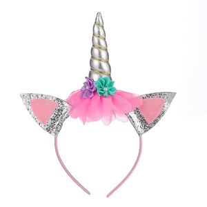 Detailed close-up of unicorn headband with silver horn, pink glitter ears and colorful flowers