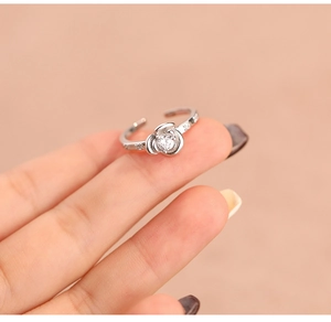 Close-up of a silver rose flower ring with zircon stones on a model's finger