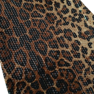 Macro shot of sequined leopard print fabric with shimmering gold and brown textures