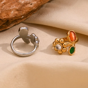 Detail of 18K gold plated floral ring with colorful gemstones on natural stone base