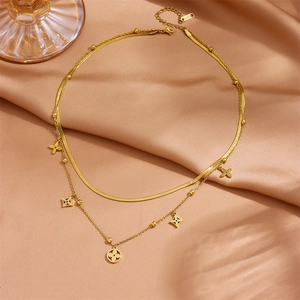 Double-layered gold flower necklace with snake chain on champagne silk background