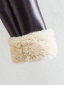 Close-up of shiny chocolate brown PU leather and thick cream faux lamb wool lining