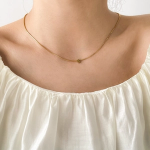 Close-up of a delicate gold plated crescent moon pendant on a minimalist chain necklace