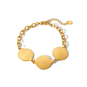 Close-up of gold stainless steel link bracelet with triple spiral charms and heart tag