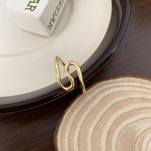 Macro close-up of S925 sterling silver gold wavy ring with hallmark and wood background