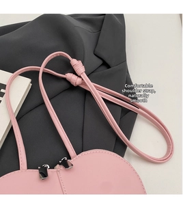 Dettaglio della borsa rosa opaca con tracolla in ecopelle annodata e zip in metallo argento