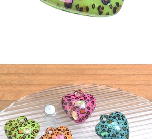 Macro detail of colorful leopard print heart pendants with UV coating for DIY jewelry