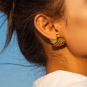 Golden shell textured stud earrings in 18k gold plated stainless steel on model