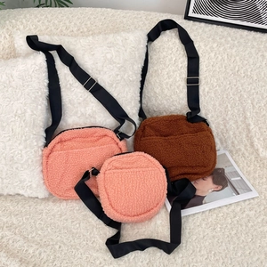 Three plush crossbody bags in pink and brown, featuring adjustable black nylon straps