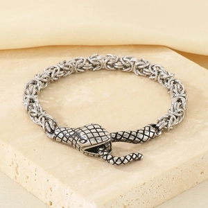 Macro view of Byzantine weave chain and detailed snake head clasp on stainless steel bracelet